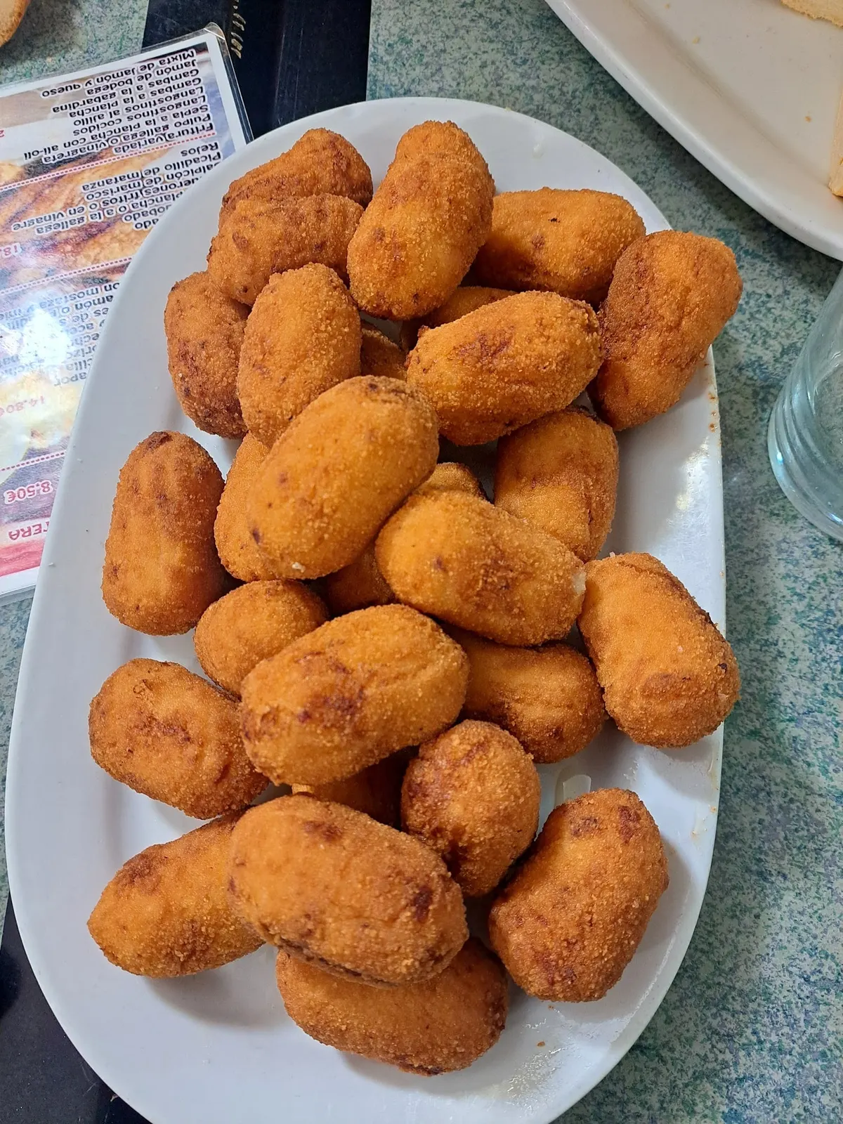 Fuente ovalada llena de croquetas de jamón doradas